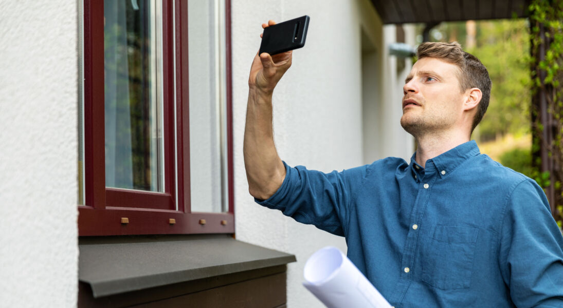 SWCS Expert immobilier réalisant lexpertise dun bien à laide de son téléphone pour photographier les lieux